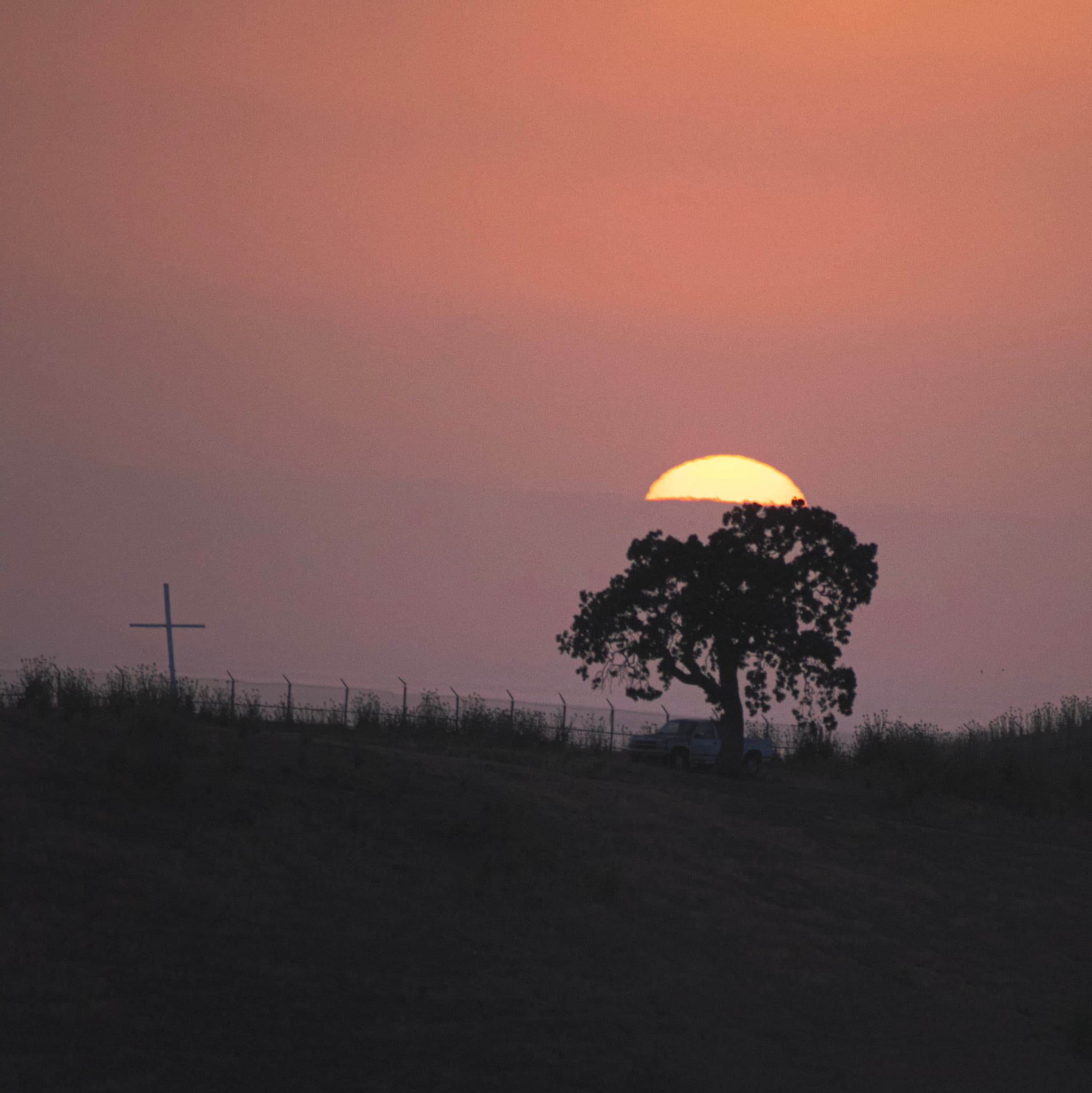 Photo of a truck on a hill with a cross